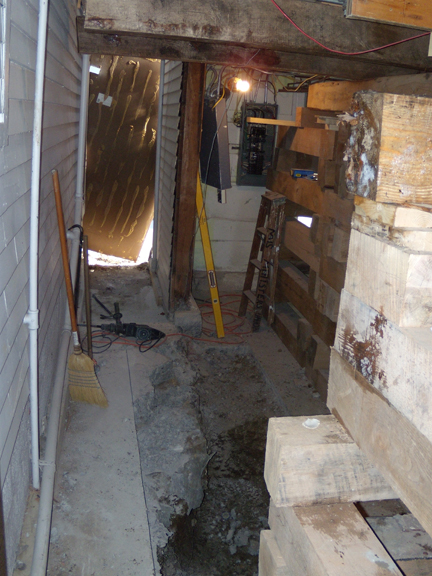 Looking east, down the alley between the Bird-Werner building (on the left) and the Shaw building (on the right). The area in the Shaw building is the dishwashing room. At the bottom of the photograph can be seen the trench for the footing.