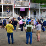 people visitng with each other in front of Bird-Werner and Shaw houses during porch blessing dedication