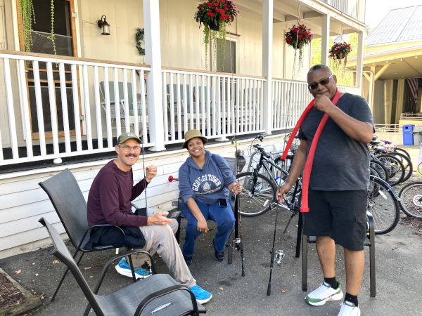 Three ECOC members gathered in front of Shaw house
