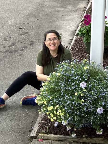 Beth Brockman Miller tending to gardening in front of shaw house