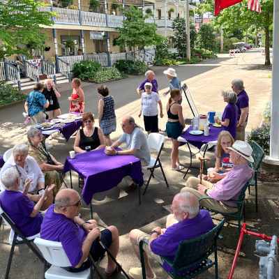 people visiting at tables at the eco social in front of shaw house